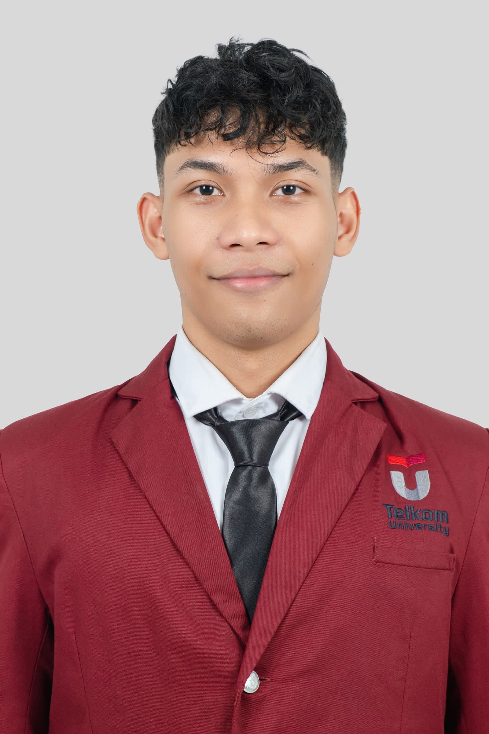 Portrait of Raihan Nur Ramadhan Sundana wearing a Telkom University academic blazer